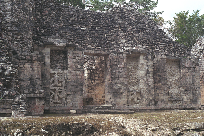 Three ornate decorative panels on the facade of Structure I showing serpent mask profiles