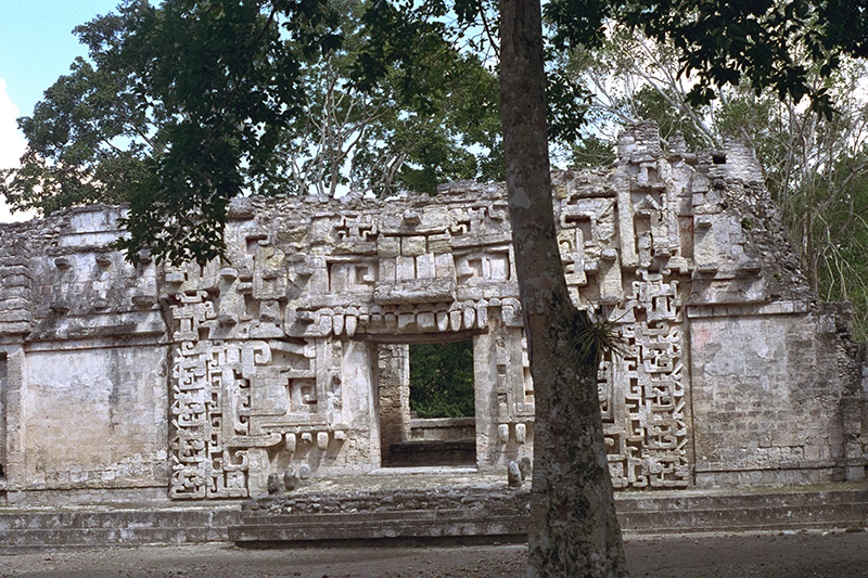 Close-up of the intricate stone mosaic serpent masks framing the entrance of Structure II