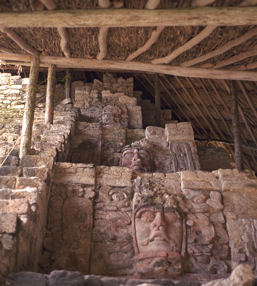A vertical column of stucco masks on the right side of the stairway